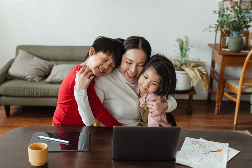 Mother embracing her two children affectionately at home